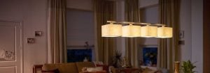 Moderna LED visilica s višestrukim sjenilima od tkanine osvjetljava ugodan dnevni boravak, prikazujući energetski učinkovita i elegantna rješenja kućne rasvjete za ambijentalnu večernju udobnost.